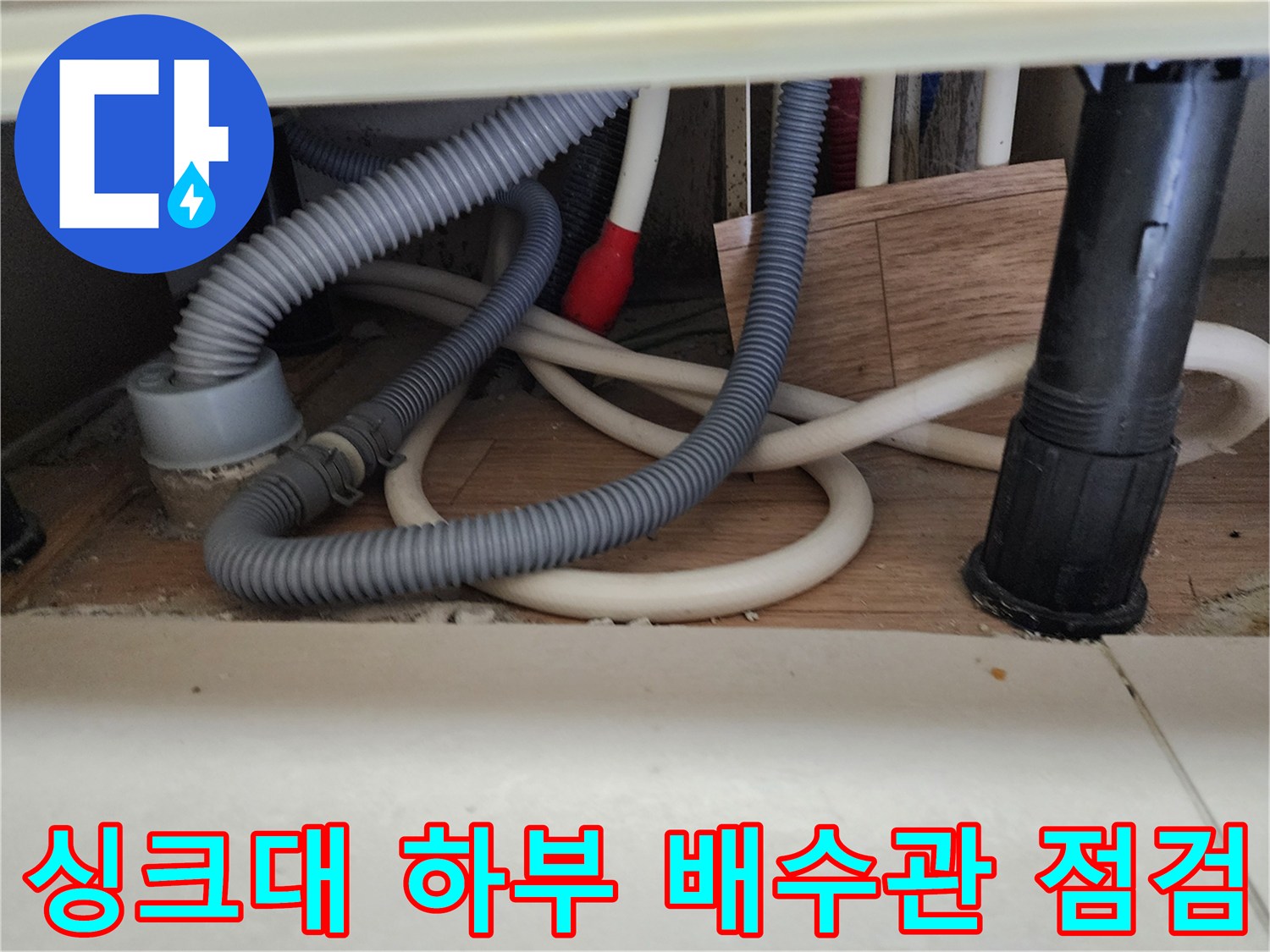 얽혀 있는 회색 주름관과 검은색 하수 배관의 연결 상태
