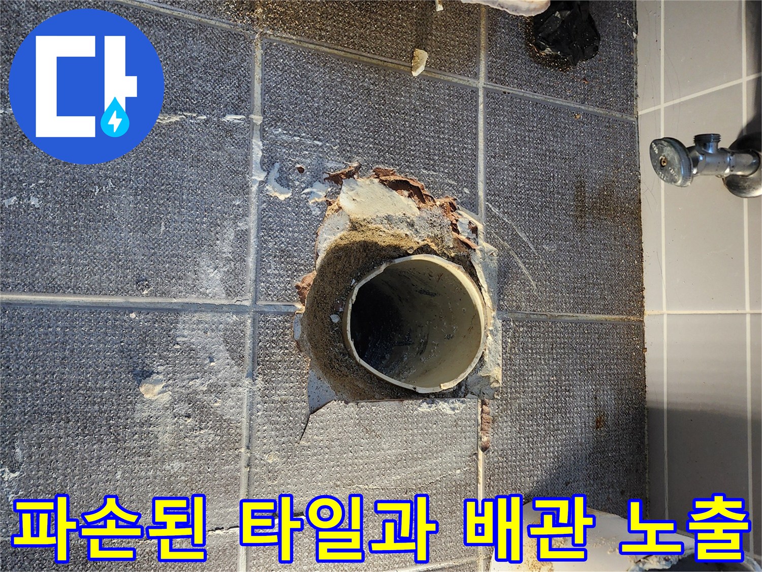 배관 주변의 훼손된 타일 마감재와 드러난 하수관 부위