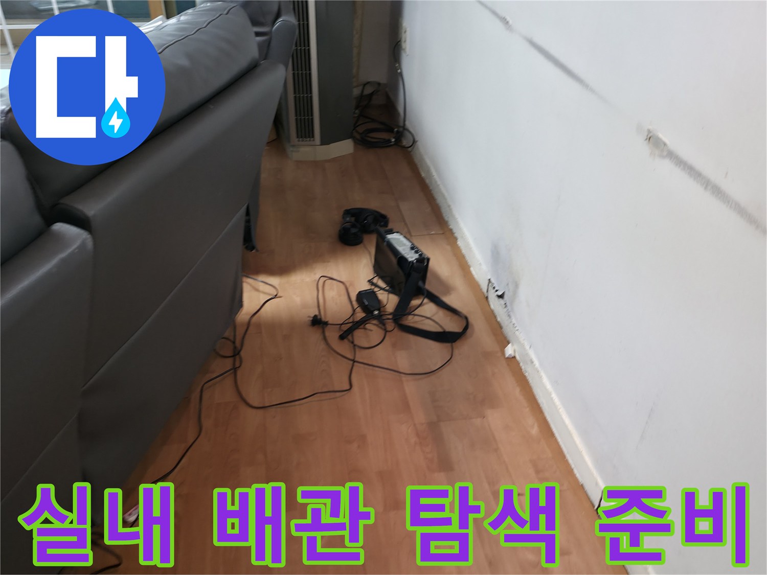 거실 소파 근처-배관 누수 지점을 추적하기 위한 정밀 장비 세팅
