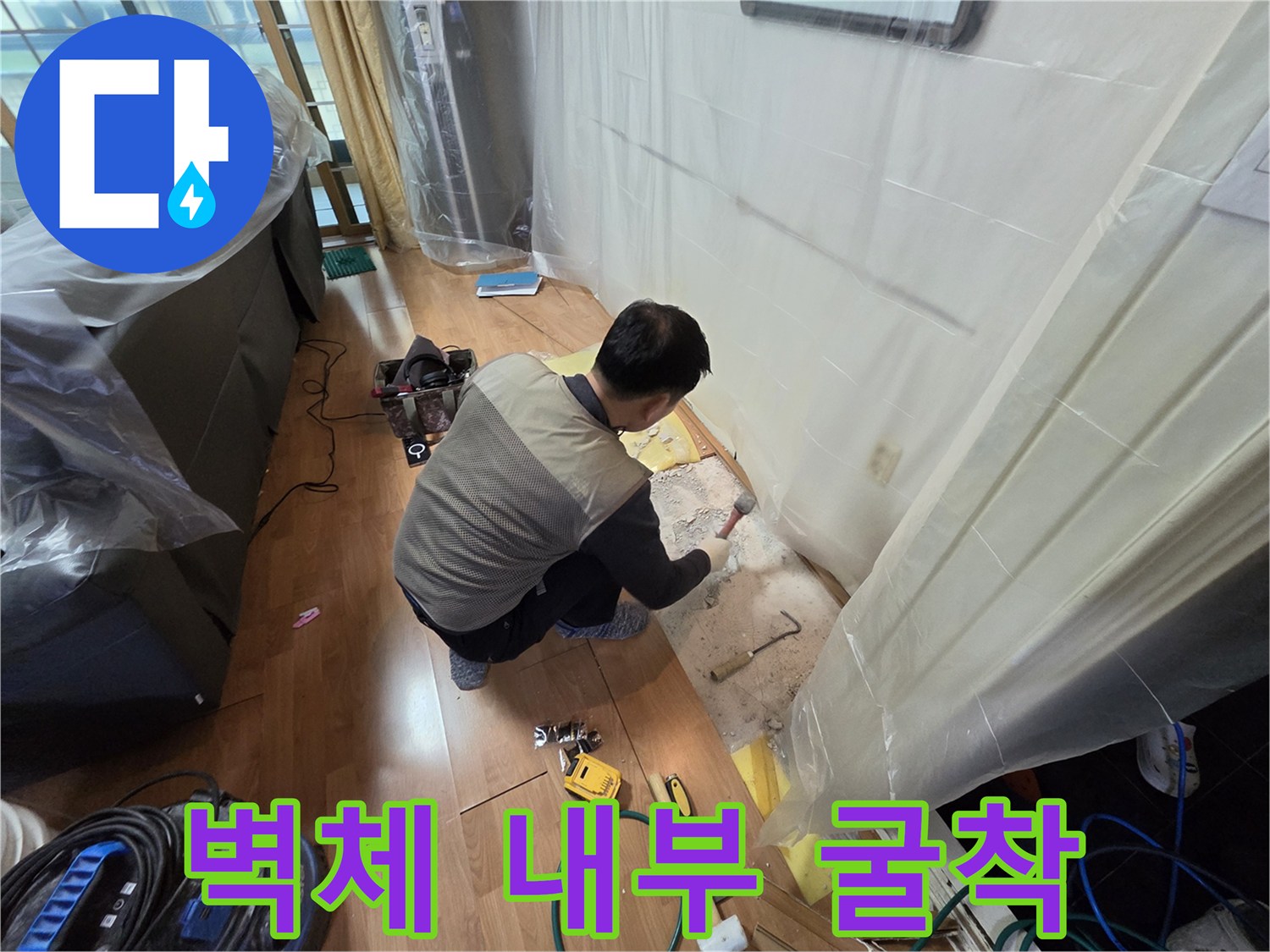 누수 지점 확인을 위해 벽면 하단을 조심스럽게 파내는 공사 현장 사진