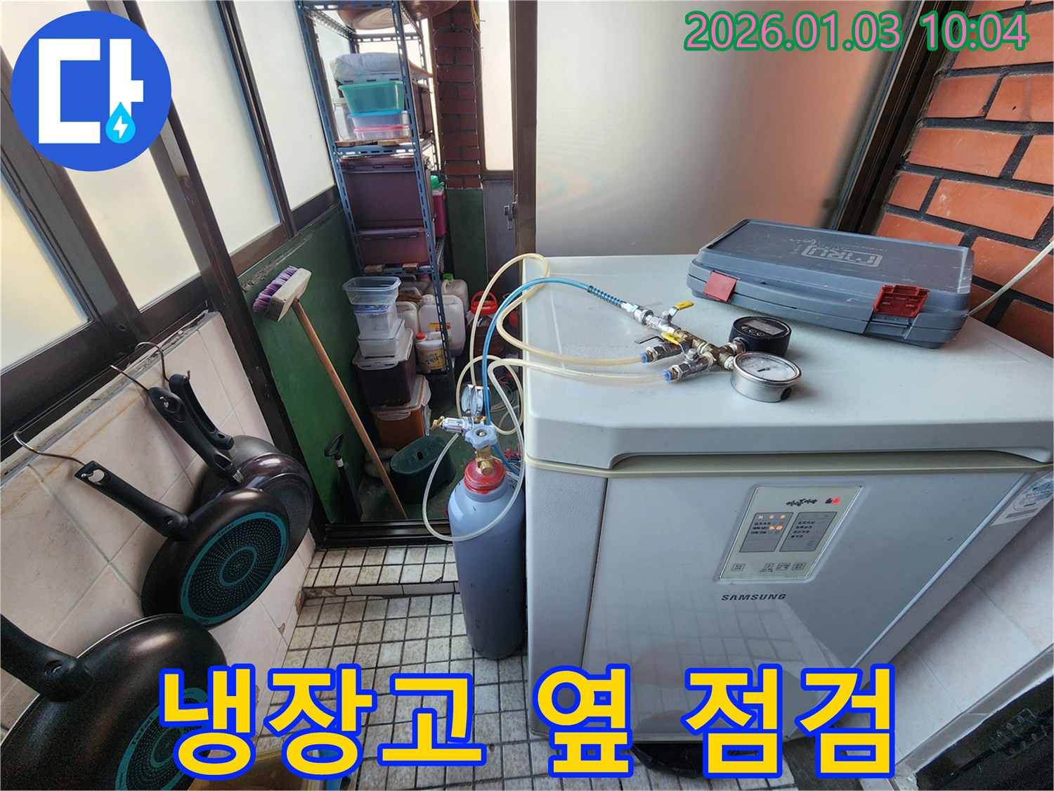 냉장고 옆에서 누수 탐지 장비를 사용하여 압력 테스트를 진행하고 있습니다 - 미세한 압력 변화도 놓치지 않습니다.