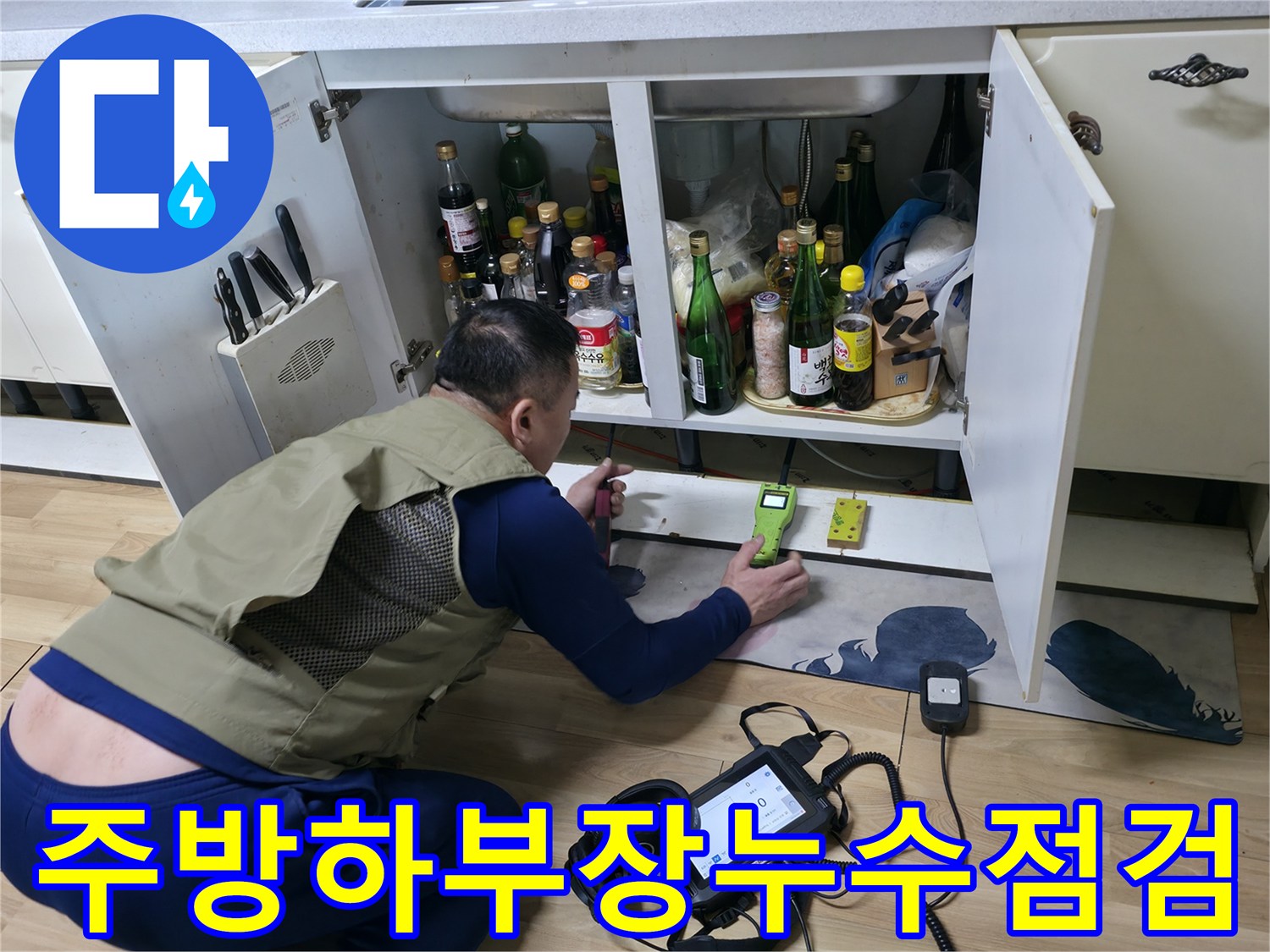 싱크대 아래 배관 부근에서 가스 탐지기를 작동시켜 위치를 특정하는 모습입니다.