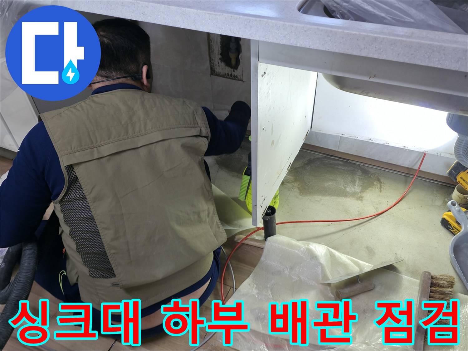 주방 싱크대 밑 공간에서 진행 중인 수도 배관 누수 진단 작업