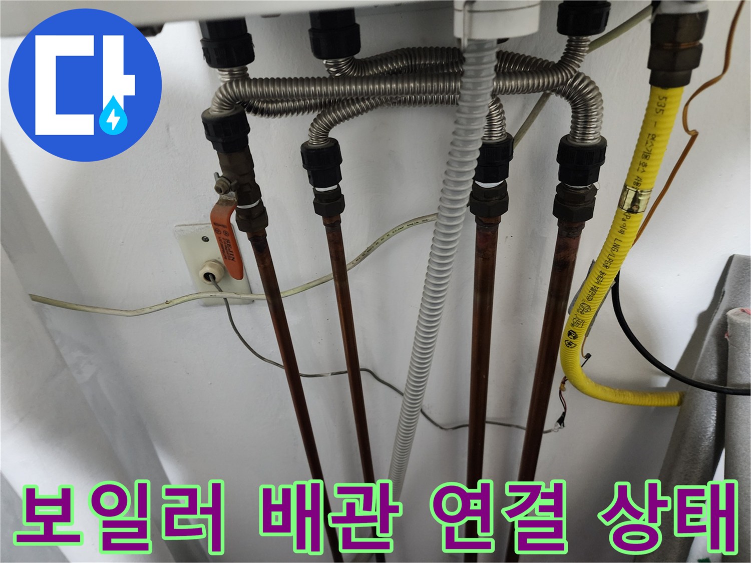 보일러 하부의 은색 주름관과 구리 배관이 연결된 모습