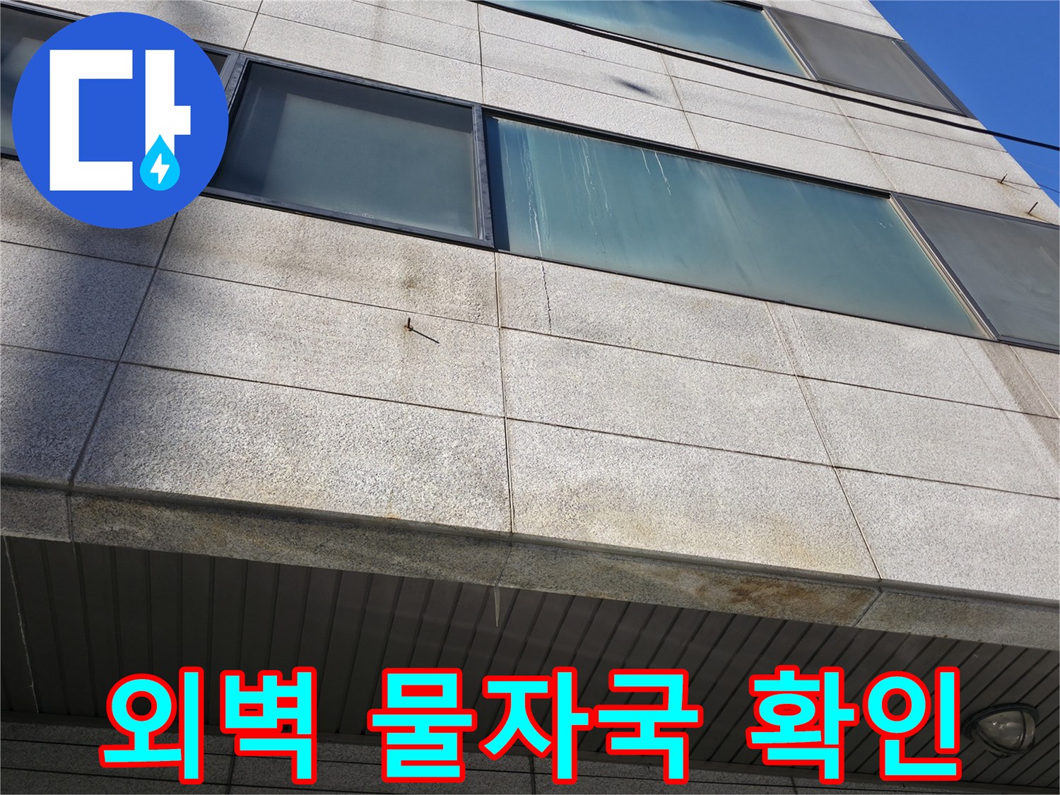 건물 외벽의 석재 패널 부위에 나타난 습기 흔적과 얼룩 현상