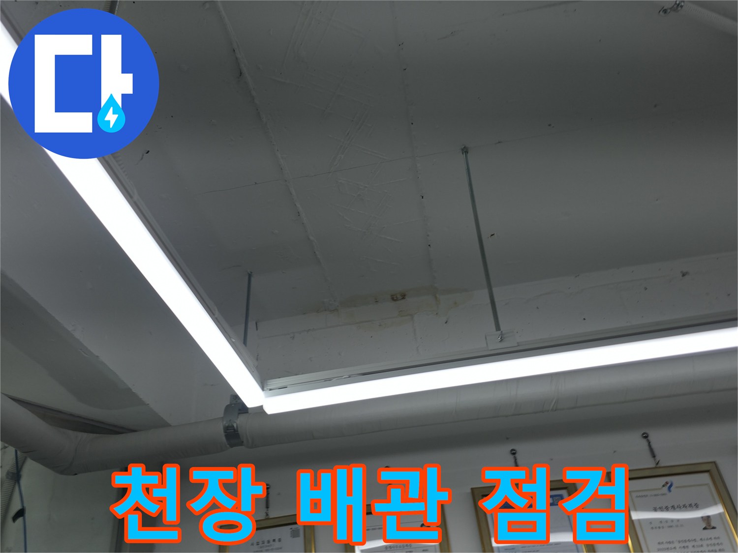 천장 내부에 설치된 흰색 배관과 조명 시설물 상태를 확인하는 모습