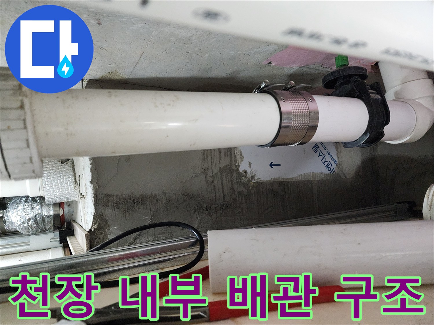하수 배관과 고정용 클램프가 설치된 천장 내부 작업 환경