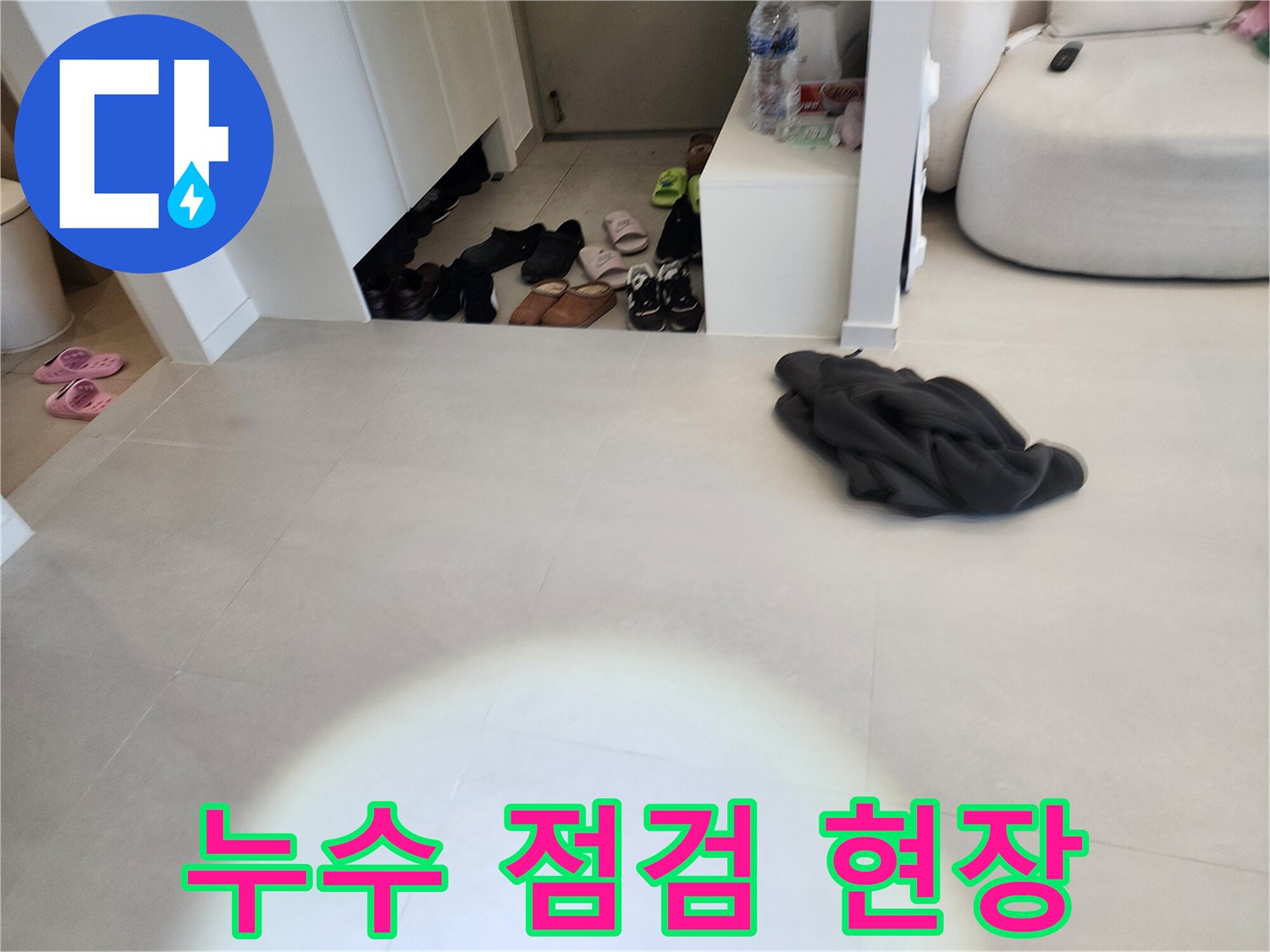 점검을 위해 확인하고 있는 거실 타일과 신발장 주변