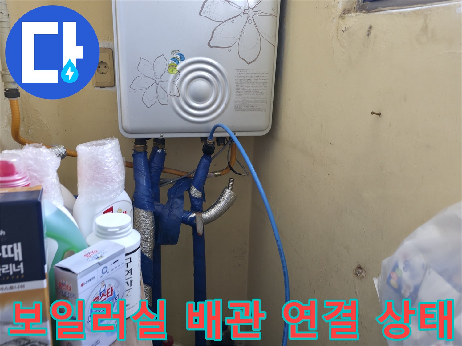 보일러 하단에 연결된 여러 종류의 배관과 밸브 모습