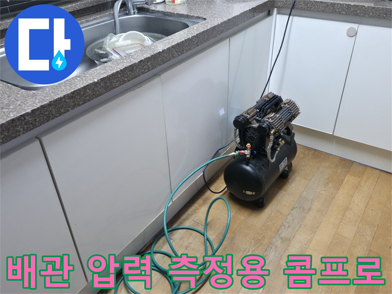 싱크대 하단 작업 공간-누수 탐지를 위해 연결된 에어 호스와 장비