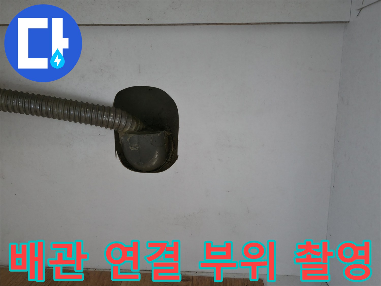 벽체 배수 지점에 연결된 주름진 형태의 배관 사진입니다.