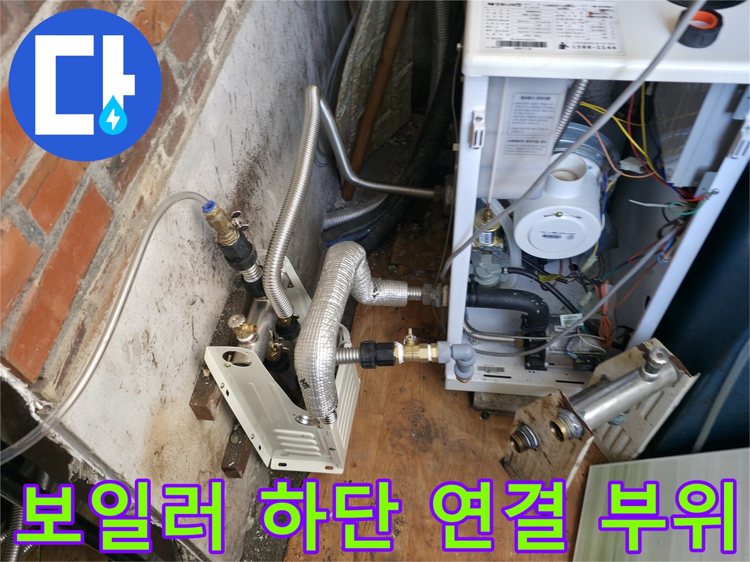 보일러 본체 아래 금속 배관과 밸브의 결합 상태를 촬영한 사진입니다.