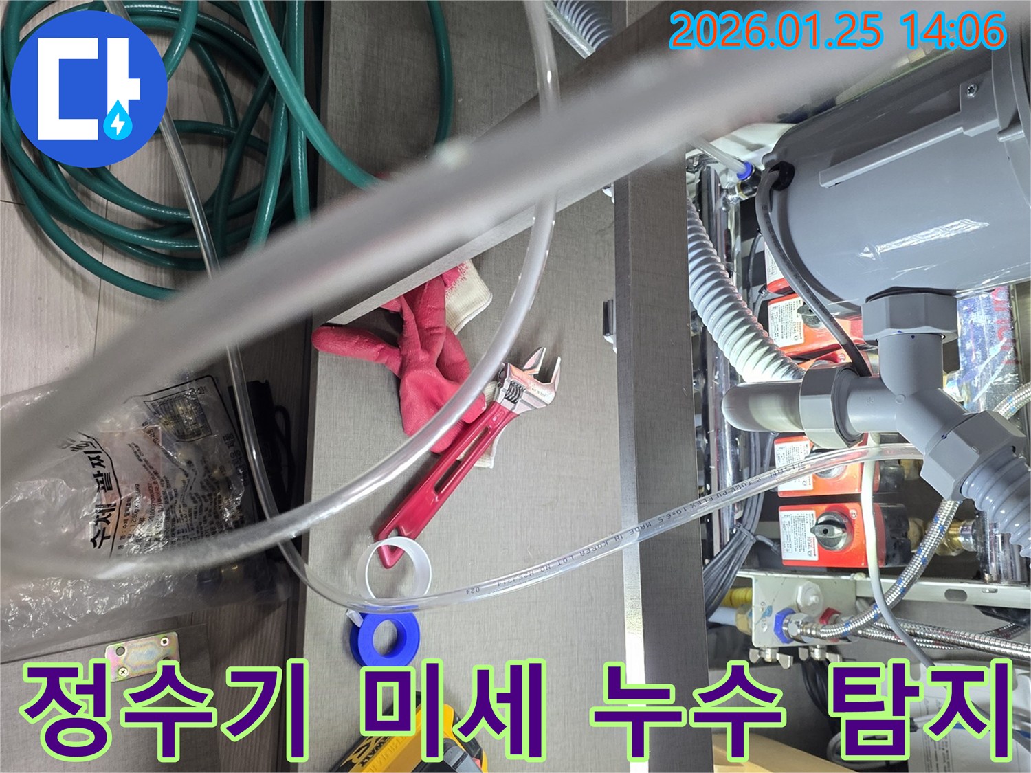 이 이미지는-정수기 연결부에서-발생한 미세 누수를-정확하게 탐지하고-수리하기 위해-전문가가-공구를 사용하여-작업하는-현장을 보여줍니다.