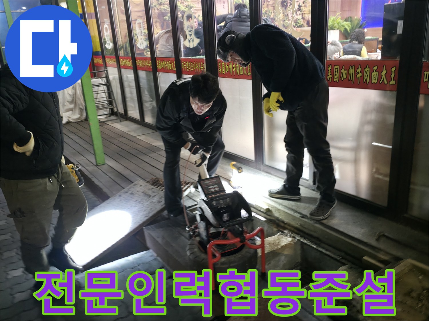 여러 명의 기술자가 협력하여 고압 세척 및 내시경 진단을 진행하는 모습