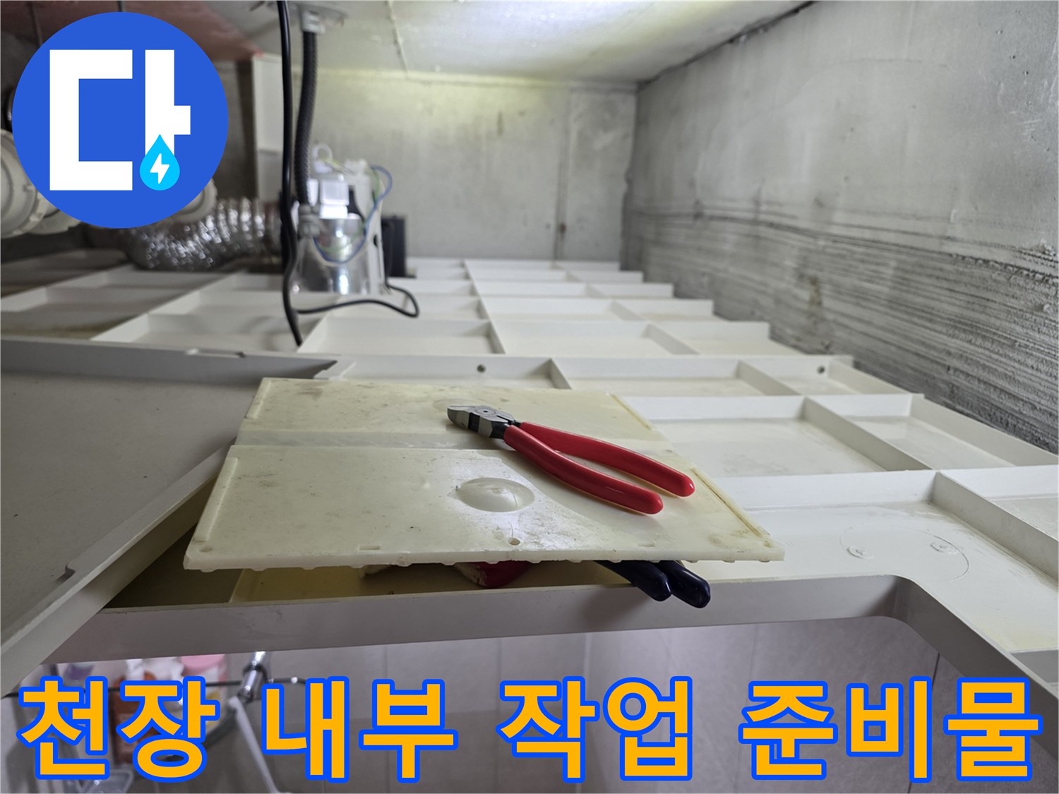 배관 점검을 위해 화장실 천장 텍스 위에 놓인 공구와 판재