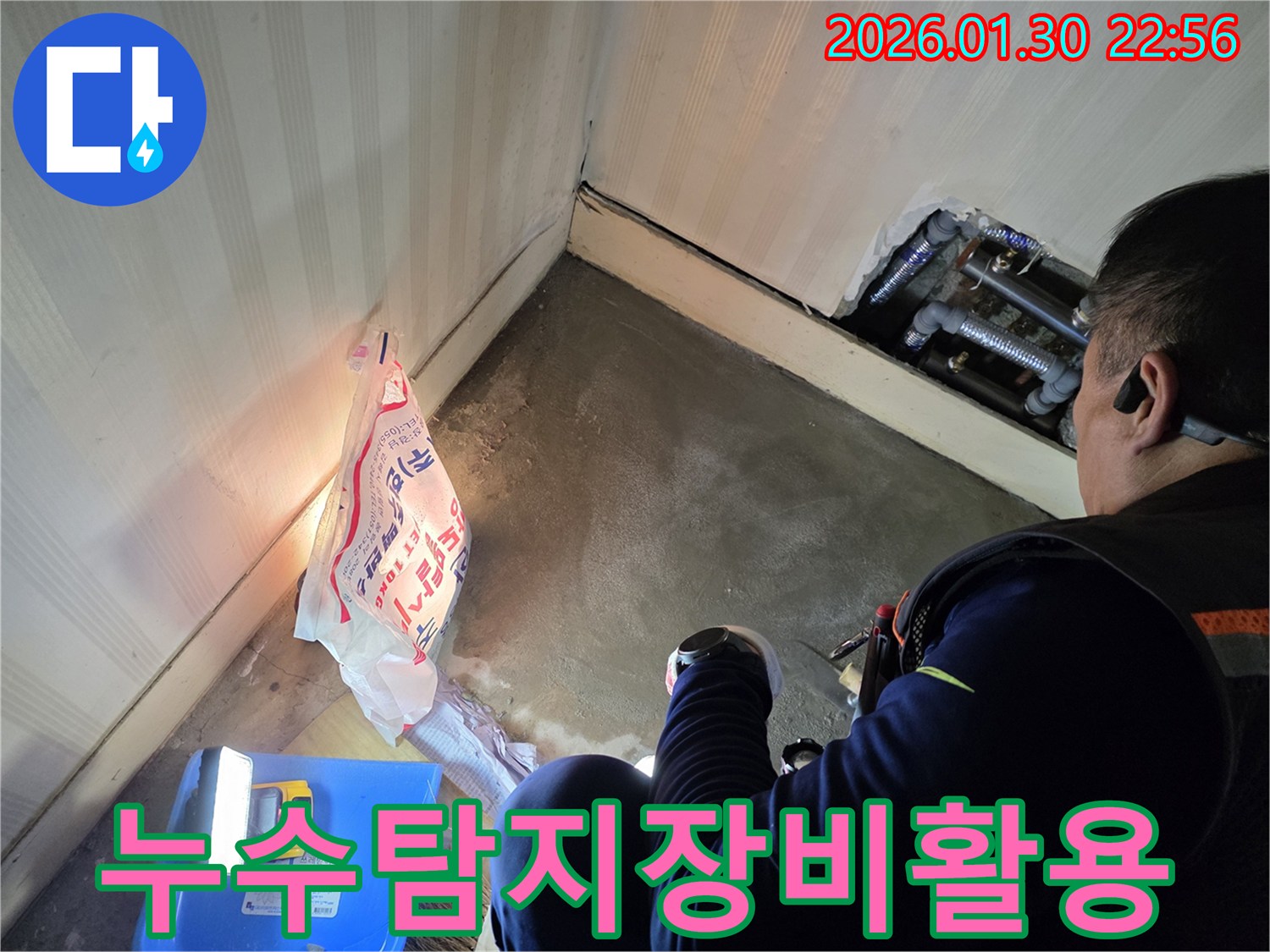 누수-엔지니어가-어두운-공간에서-전문-탐지-장비를-활용하여-배관의-누수-여부를-정밀하게-확인하는-모습입니다