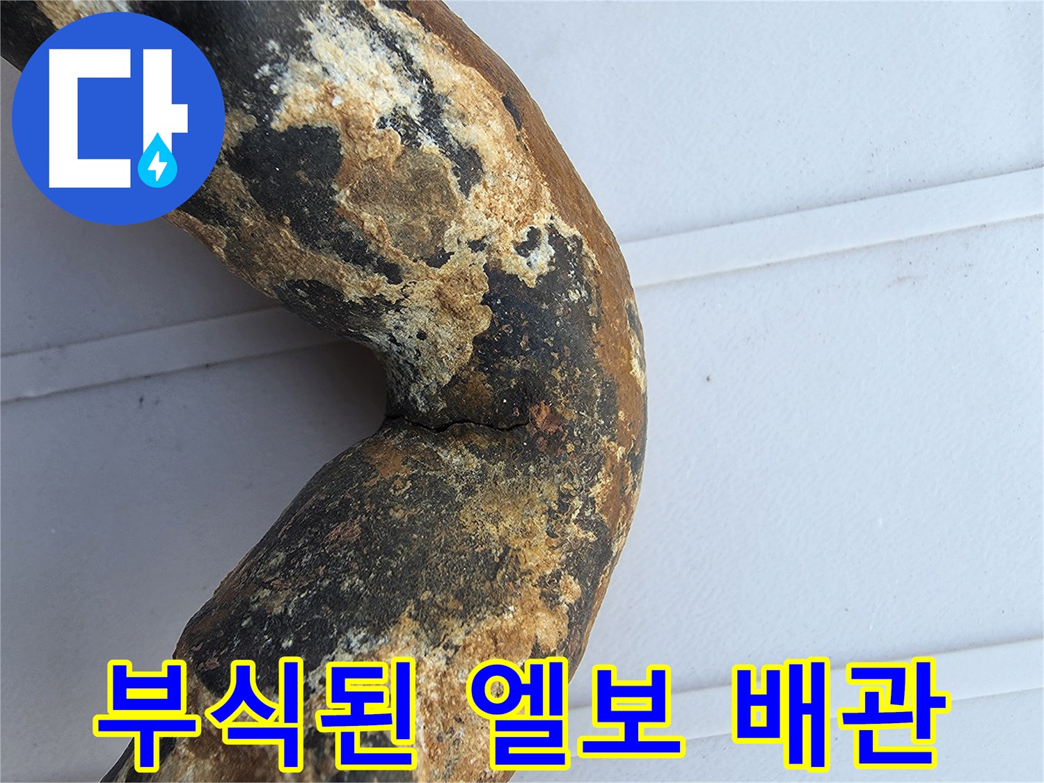 심하게 부식되어 균열이 발생한 금속 배tes 배관 엘보 구간
