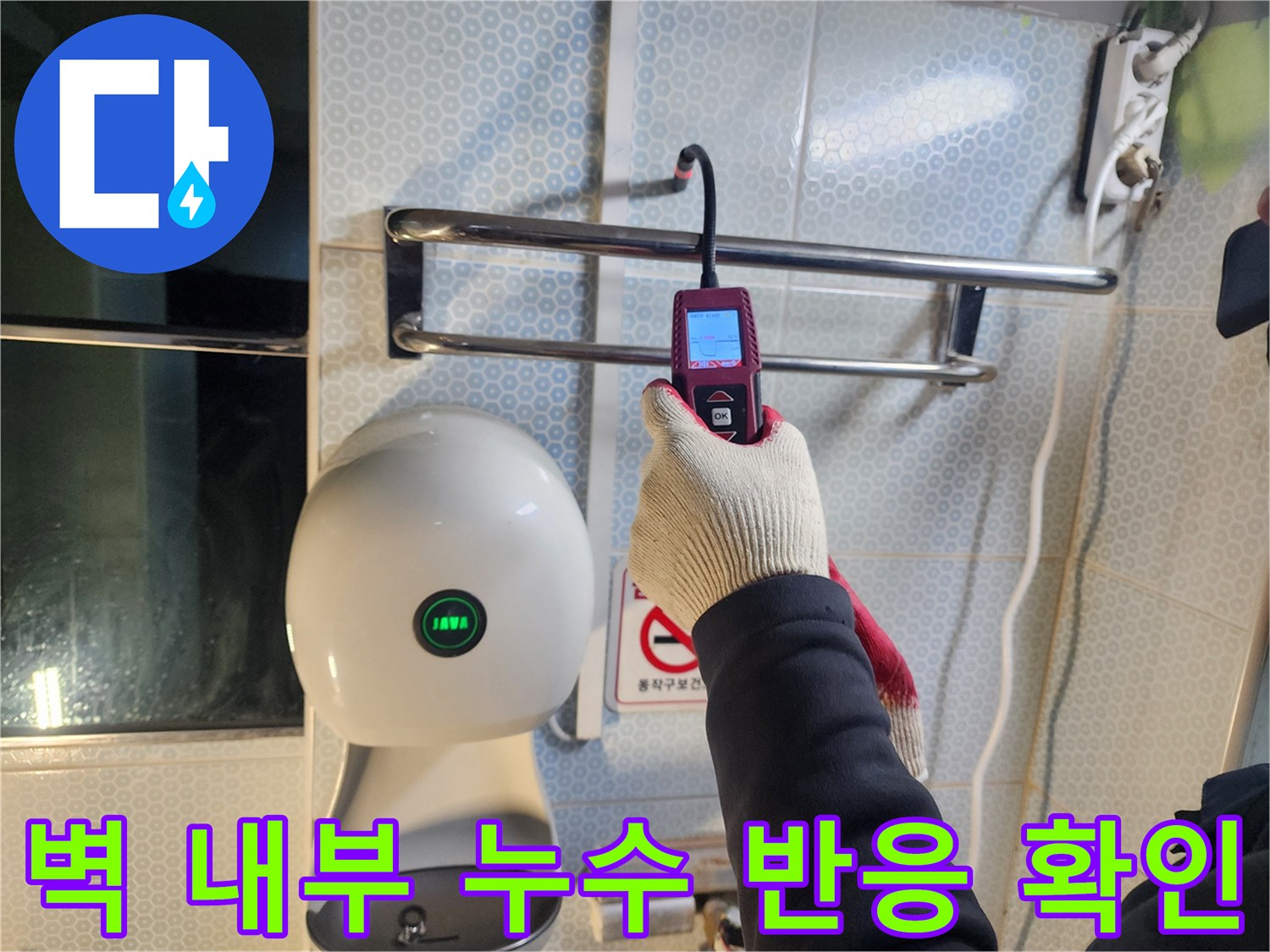탐지 장비를 벽면에 밀착시켜 누수 지점을 찾는 모습