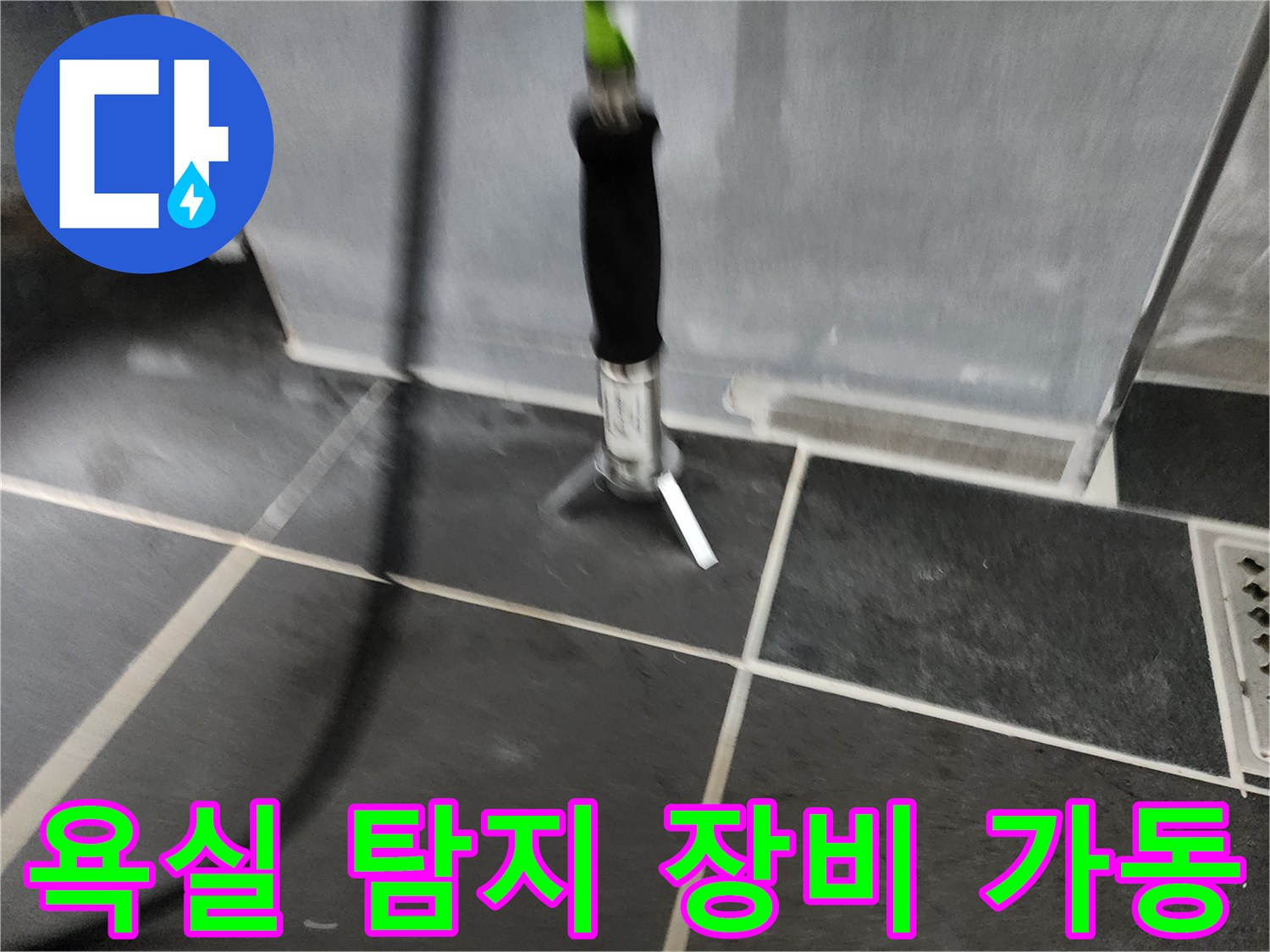 욕실 바닥 타일 위에서-누수 지점을 찾기 위해-탐지기를 사용하는 모습