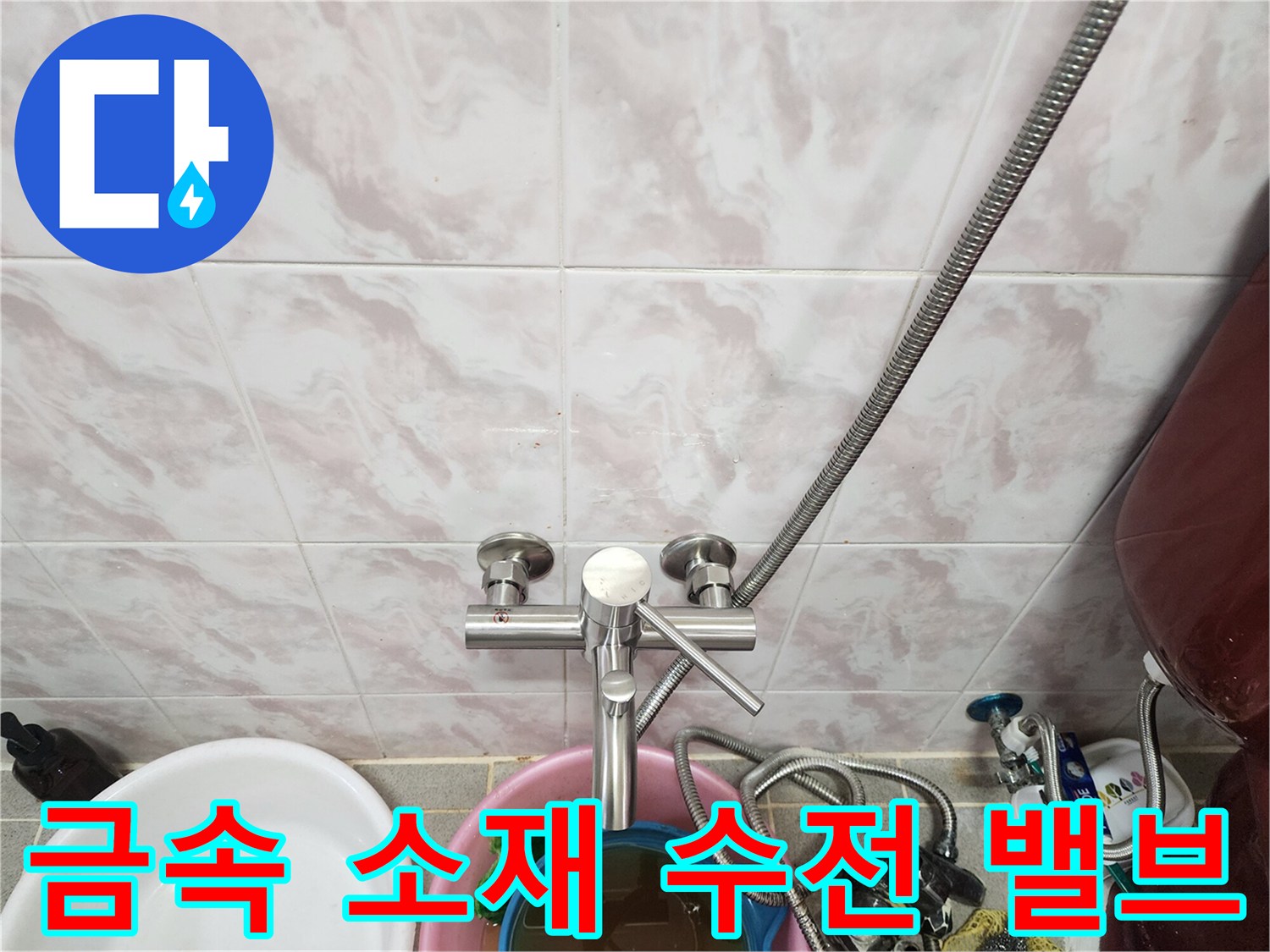 벽면 타일에 부착된 금속 재질의 수도 밸브와 연결 호스 상세 사진입니다.