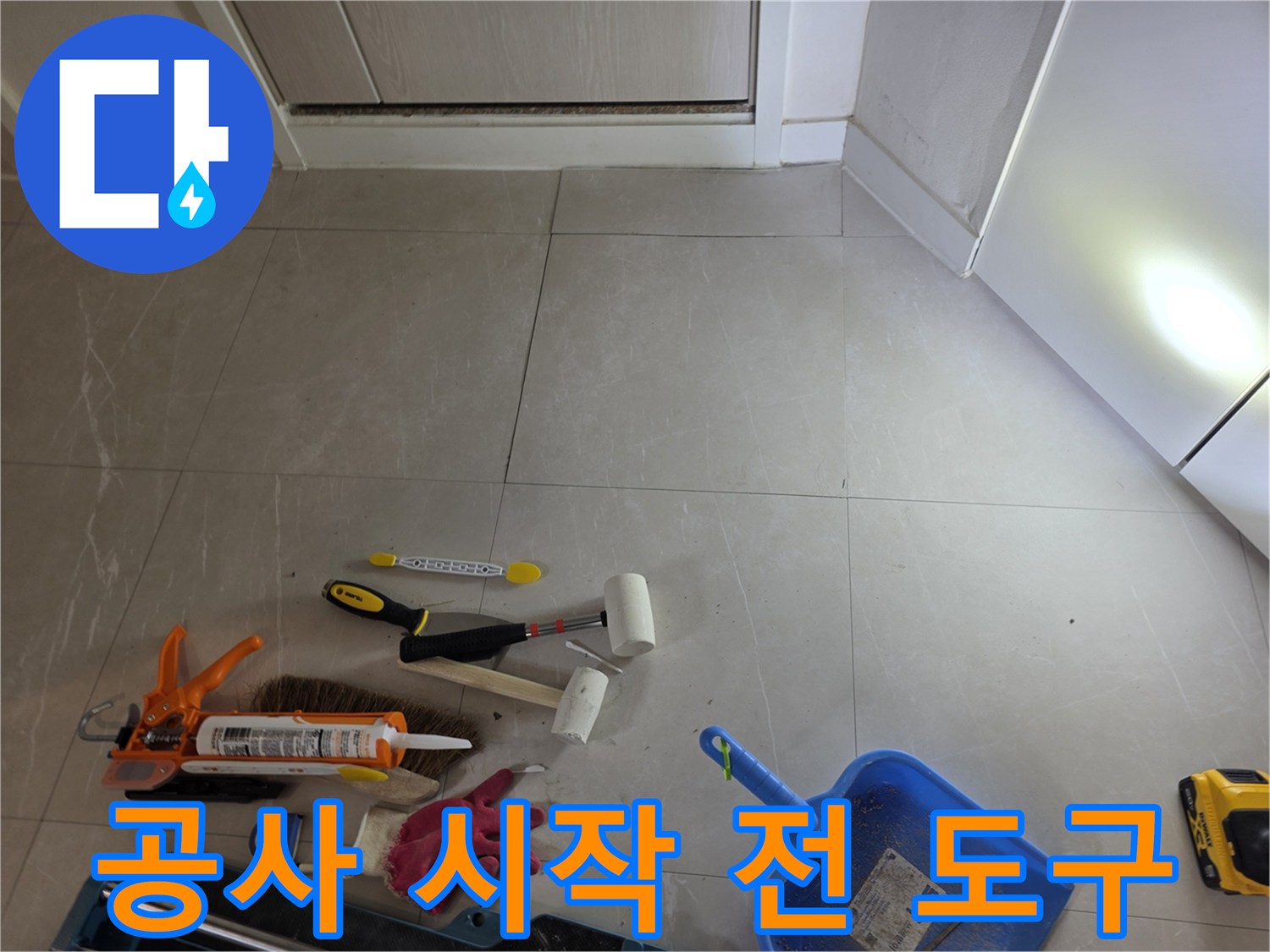 타일 바닥에 나열된 실리콘 건과 작업용 장갑 및 청소 도구