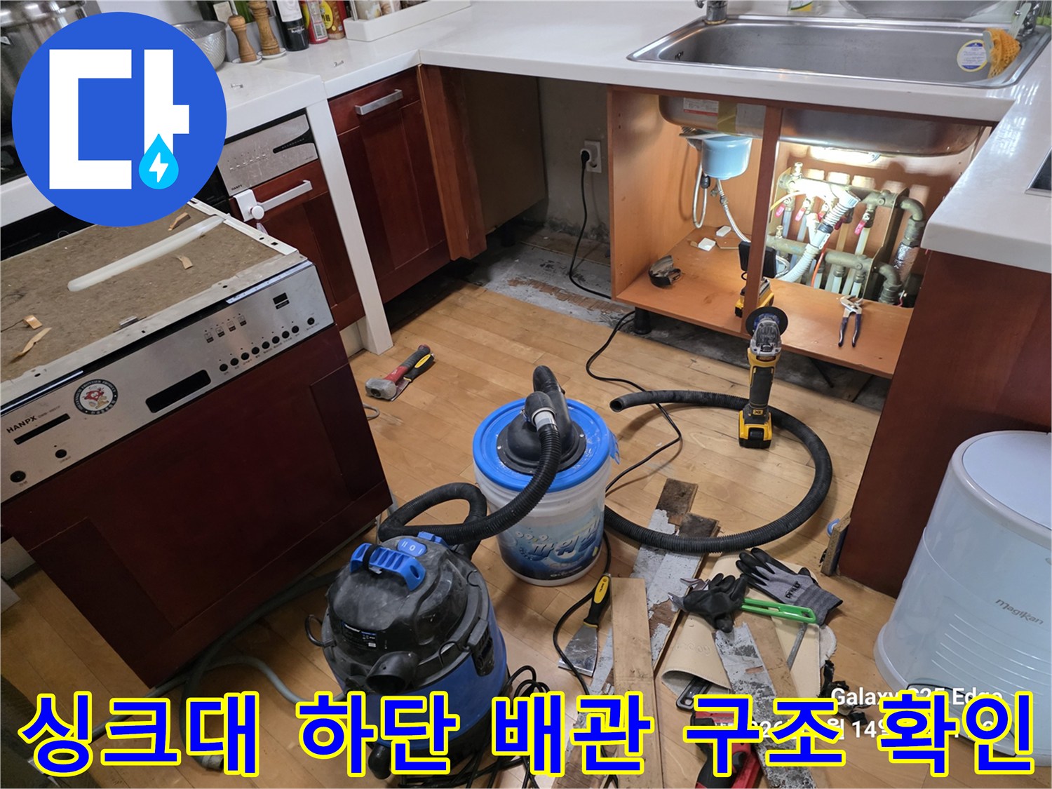 노출된 싱크대 하부 배관-석션기와 작업 도구들