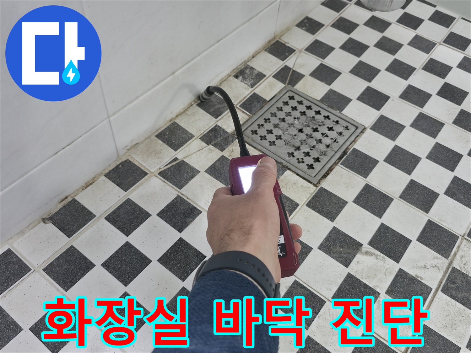 배관 탐지기 센서를 이용해 욕실 타일 면을 훑으며 누수 지점을 찾는 중