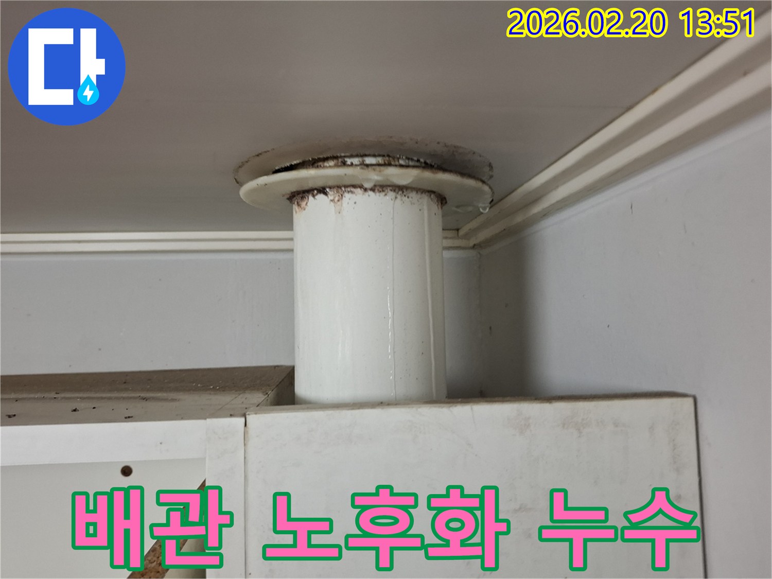 하수관의 연결부에서 물이 새고-주변에 물때가 심하게 낀 누수 현장을 담은 사진입니다.