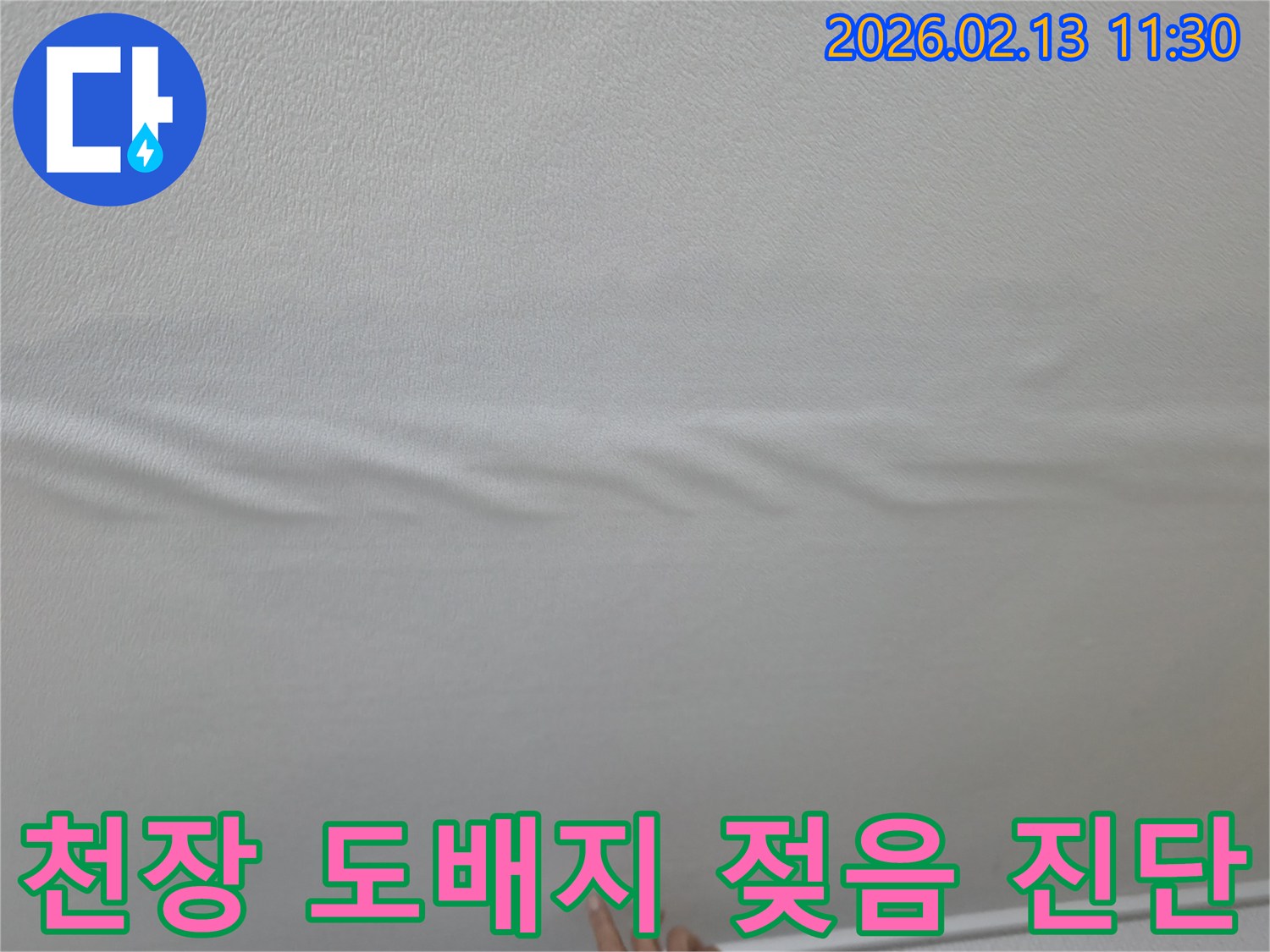 천장-도배지가-물에-젖어-울퉁불퉁해진-모습을-보여주는-사진