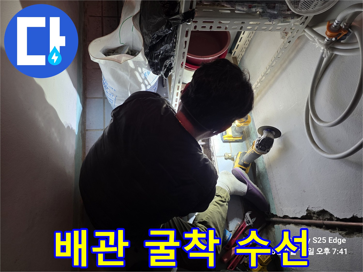 바닥을 굴착하여 노출된 배관의 결함 부위를 보수하는 장면입니다.