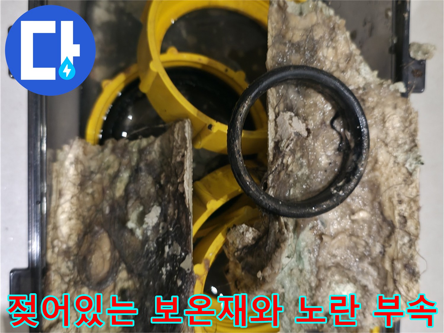 습기를 머금어 변색된 보온재와 노란색 플라스틱 배관 연결 부위