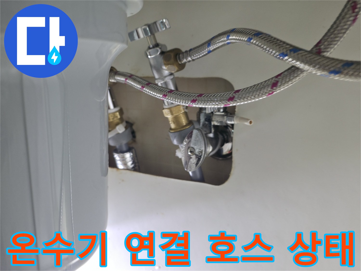싱크대 하부의 온수기 급수 밸브 및 호스 체결 모습