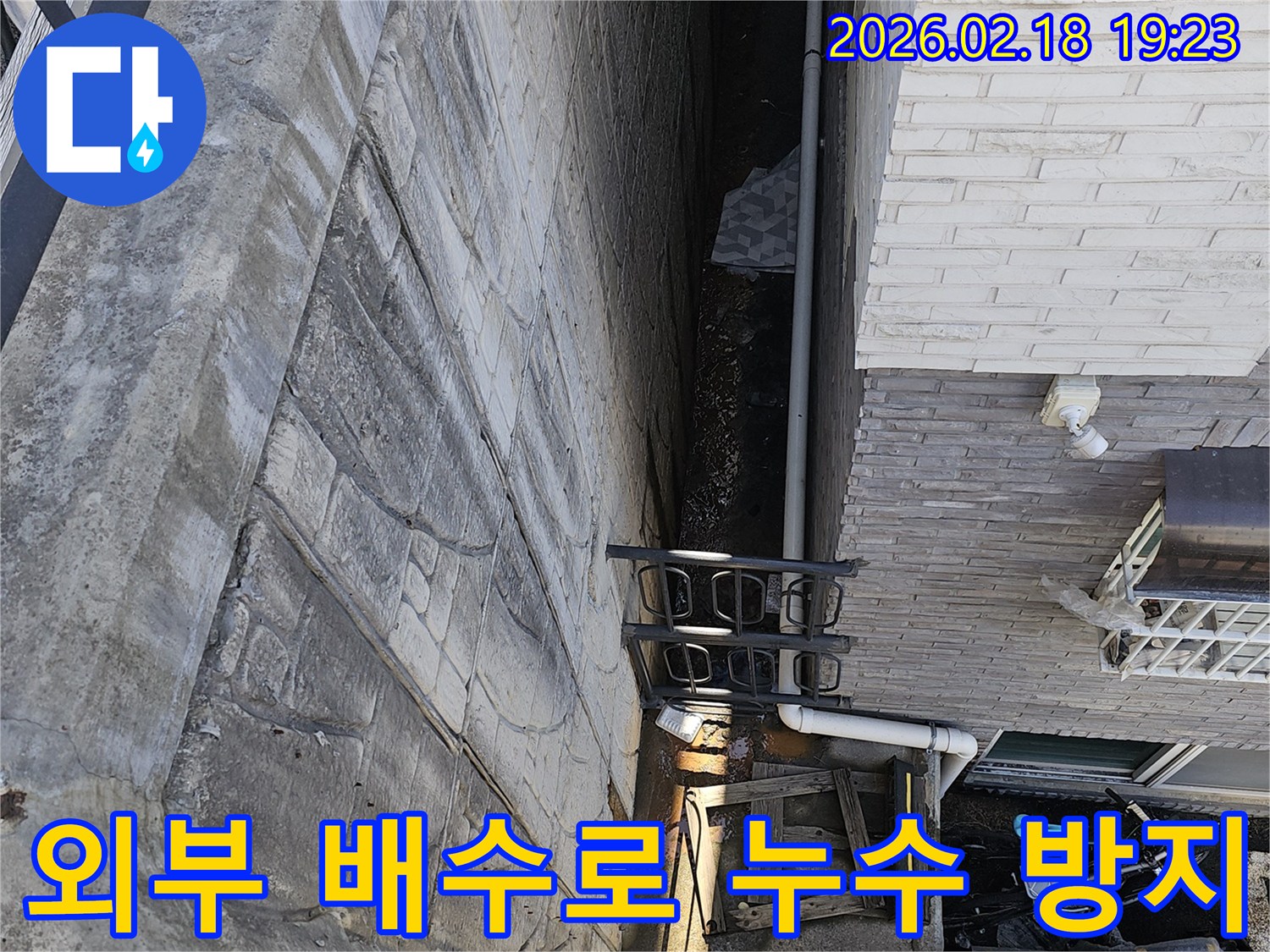 일산동구 숲속마을 주택 외부 배수로 주변에서 발생한 누수를-방지하기 위한 공사 전 전문가가 현장을 진단하는 모습입니다