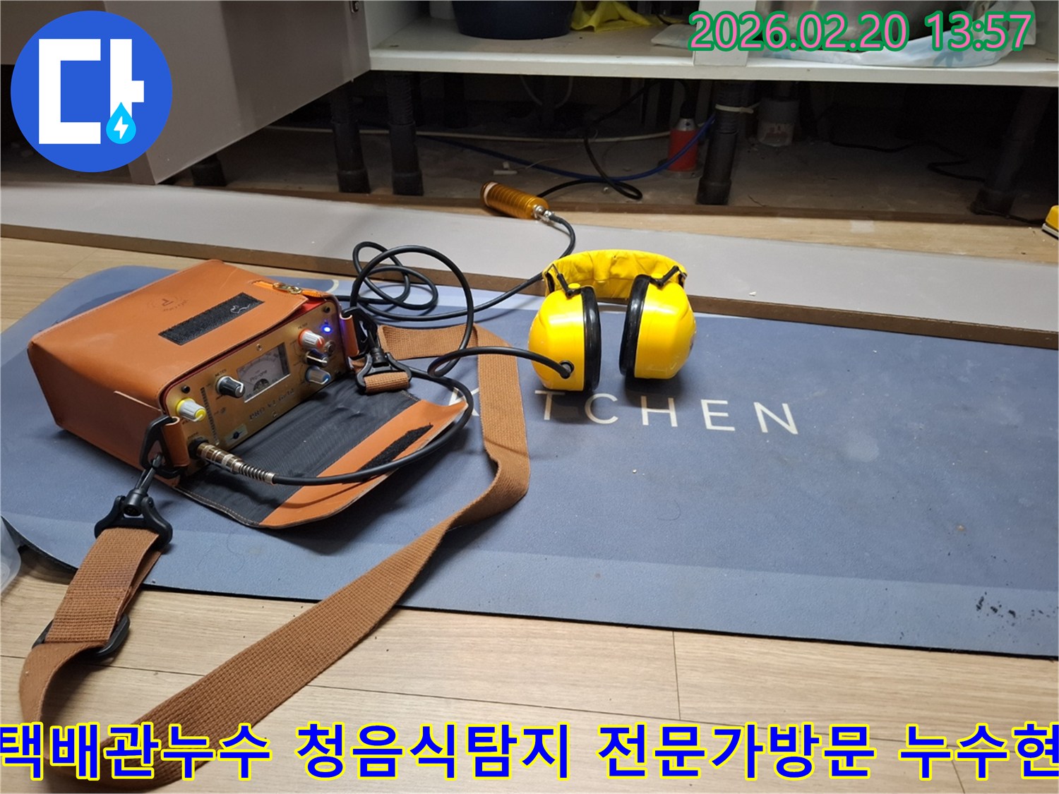 누수 엔지니어가 주방 바닥에 설치된 청음식 탐지 장비로-배관의 미세한 물샘 소리를 듣고 있습니다-정확한 누수 지점 파악을 위한 필수 장비입니다