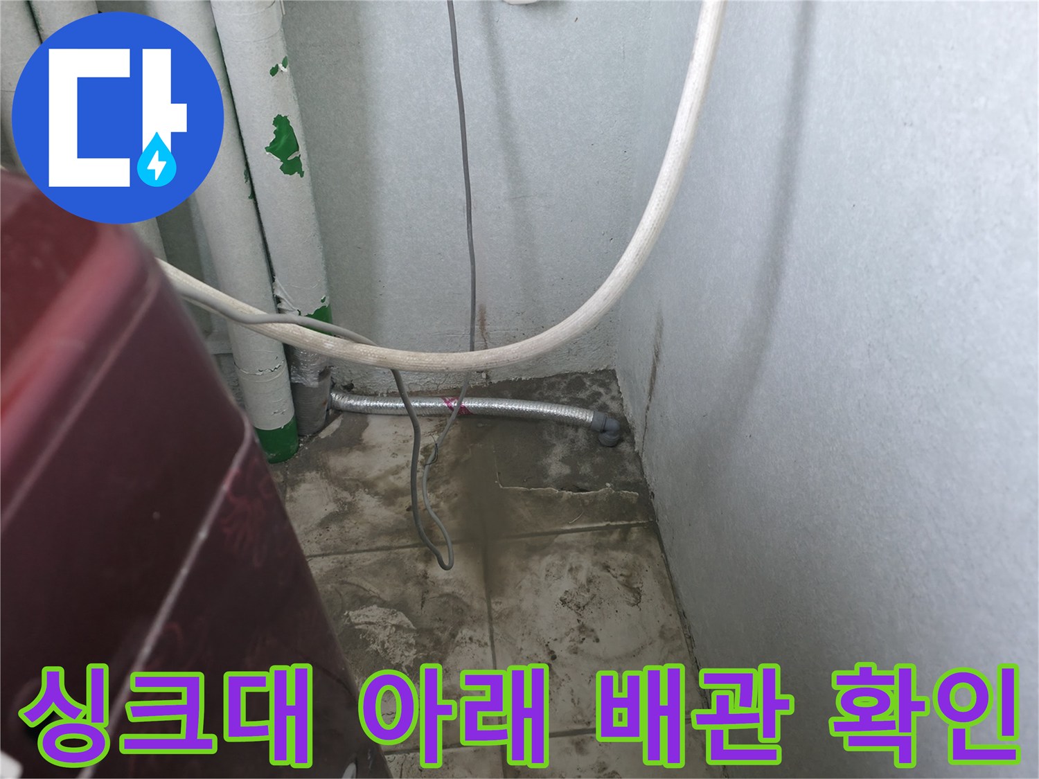 싱크대 하부장 내부의 금속 배관과 벽면 연결 상태 이미지