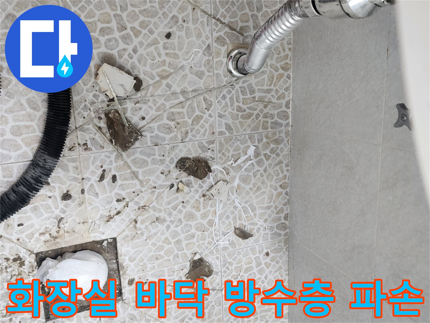 배수구 주변에 흩어진 타일 조각과 노출된 배관 상태