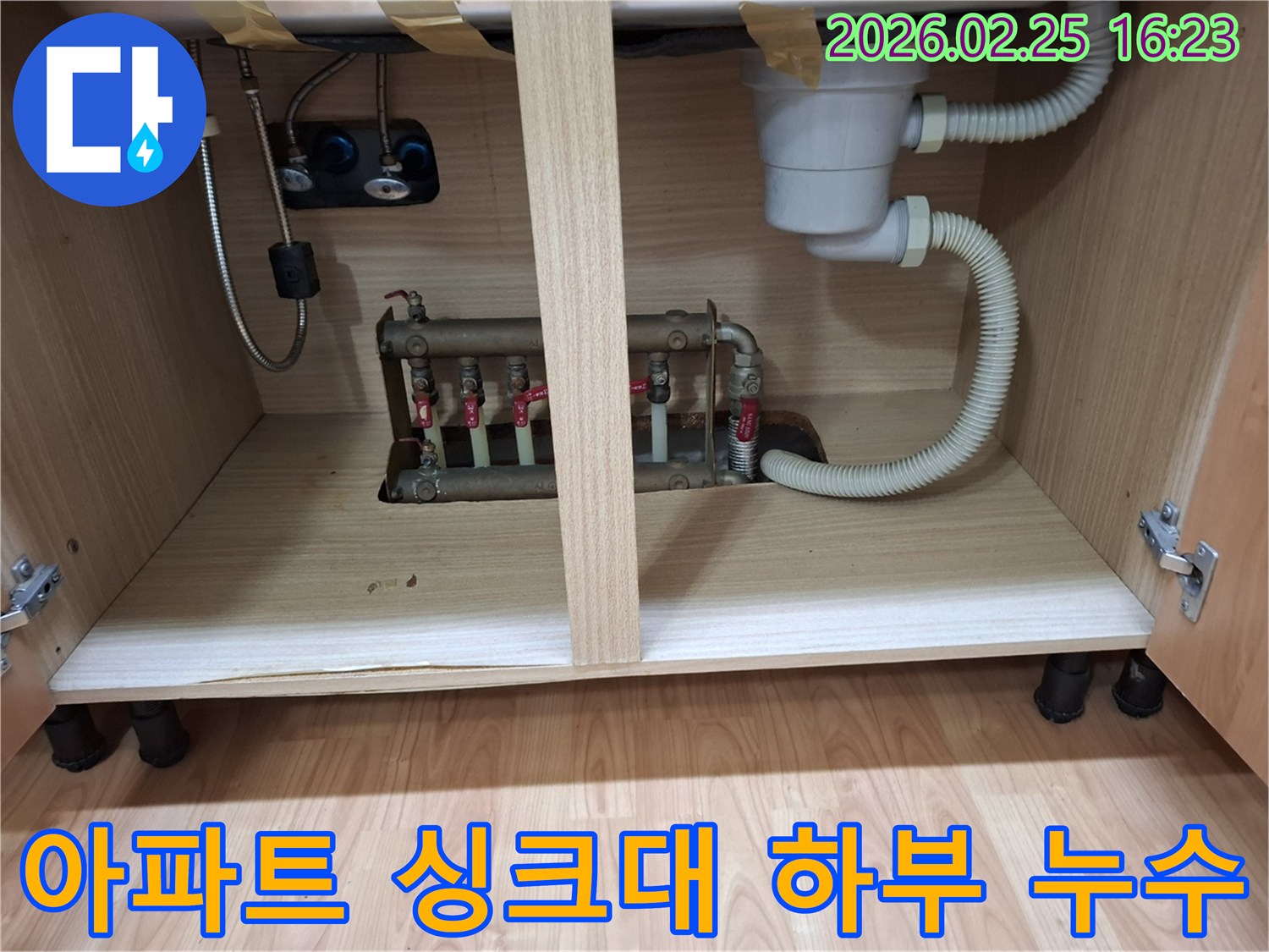아파트 싱크대 하부장 내부에 위치한 배관에서 물이 새는 현장 사진입니다