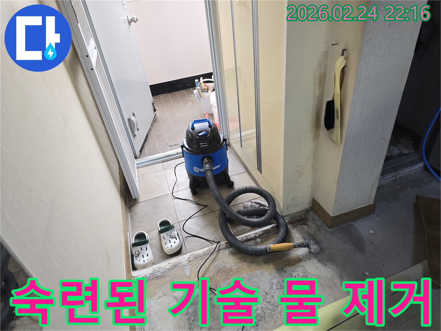 누수 현장에서-엔지니어의 숙련된 기술로-습식 청소기를 사용하여-바닥 물기를-효과적으로 제거하는 모습