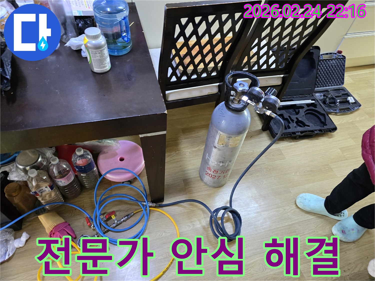 둔촌대로 누수 문제를 안심하고 해결하기 위해-전문가가 가스통과 압력 게이지를 연결하여-탐지 장비를 세팅하는 모습입니다