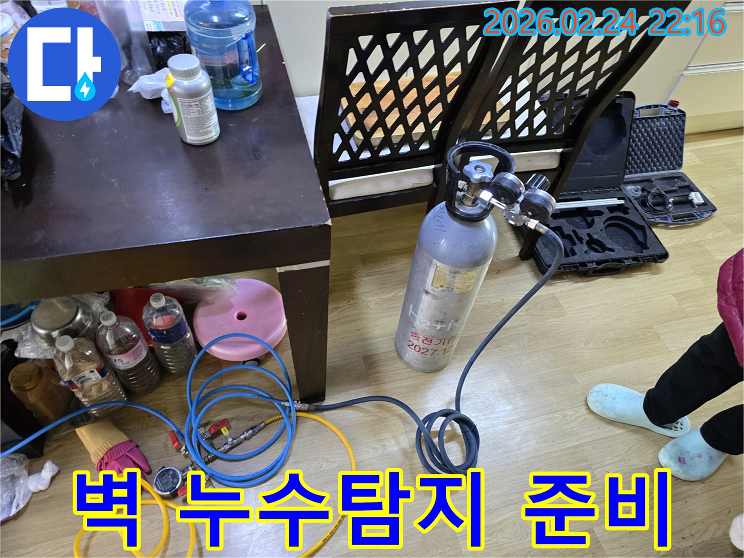 벽 내부의 누수 지점을 정확히 찾기 위해-가스통과 압력 게이지를 연결하여-탐지 장비를 세팅하는 모습입니다