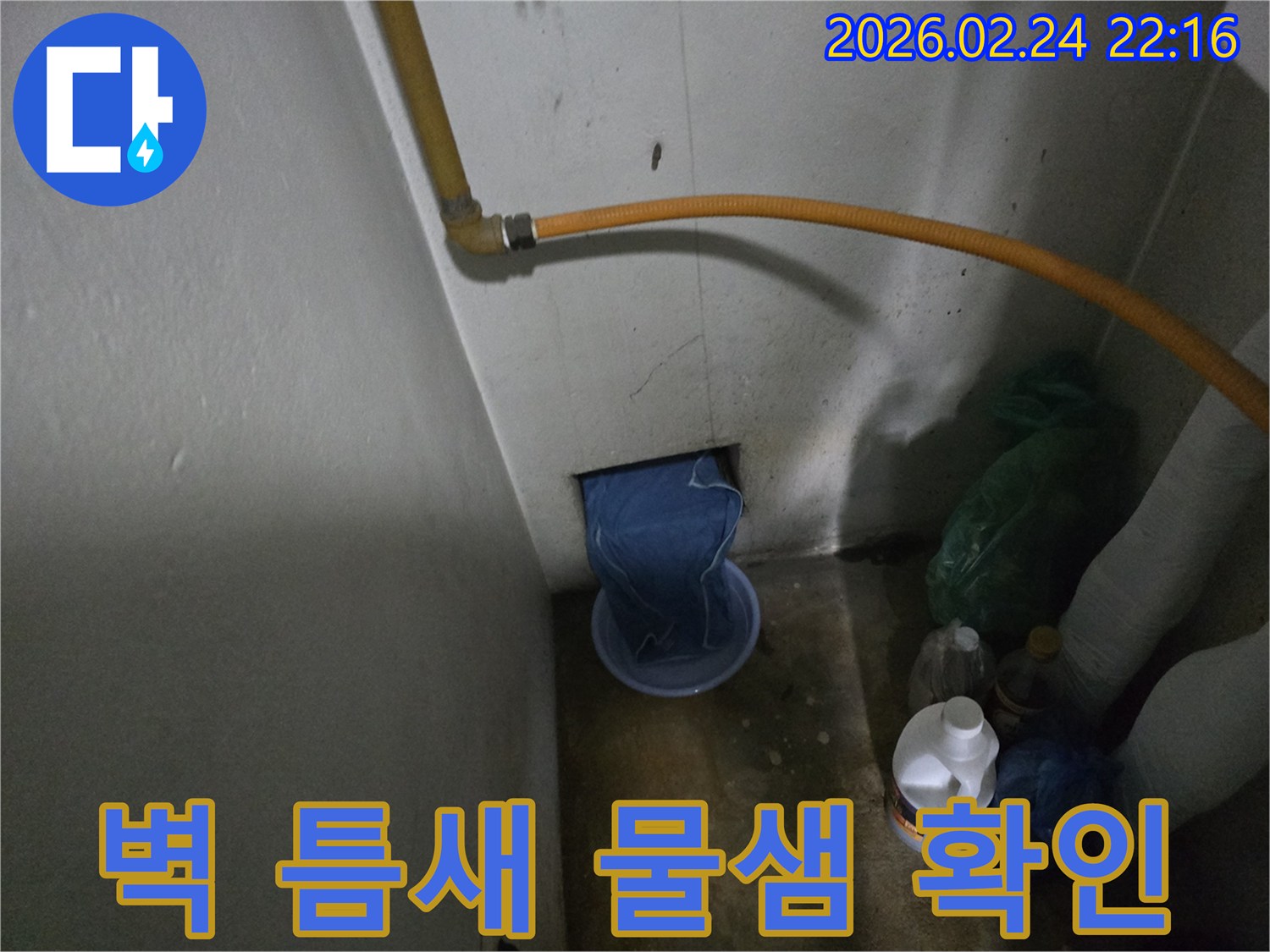 벽-하단부에서-물이-새어-나와-임시-용기에-받아지고-있는-누수-발생-장면