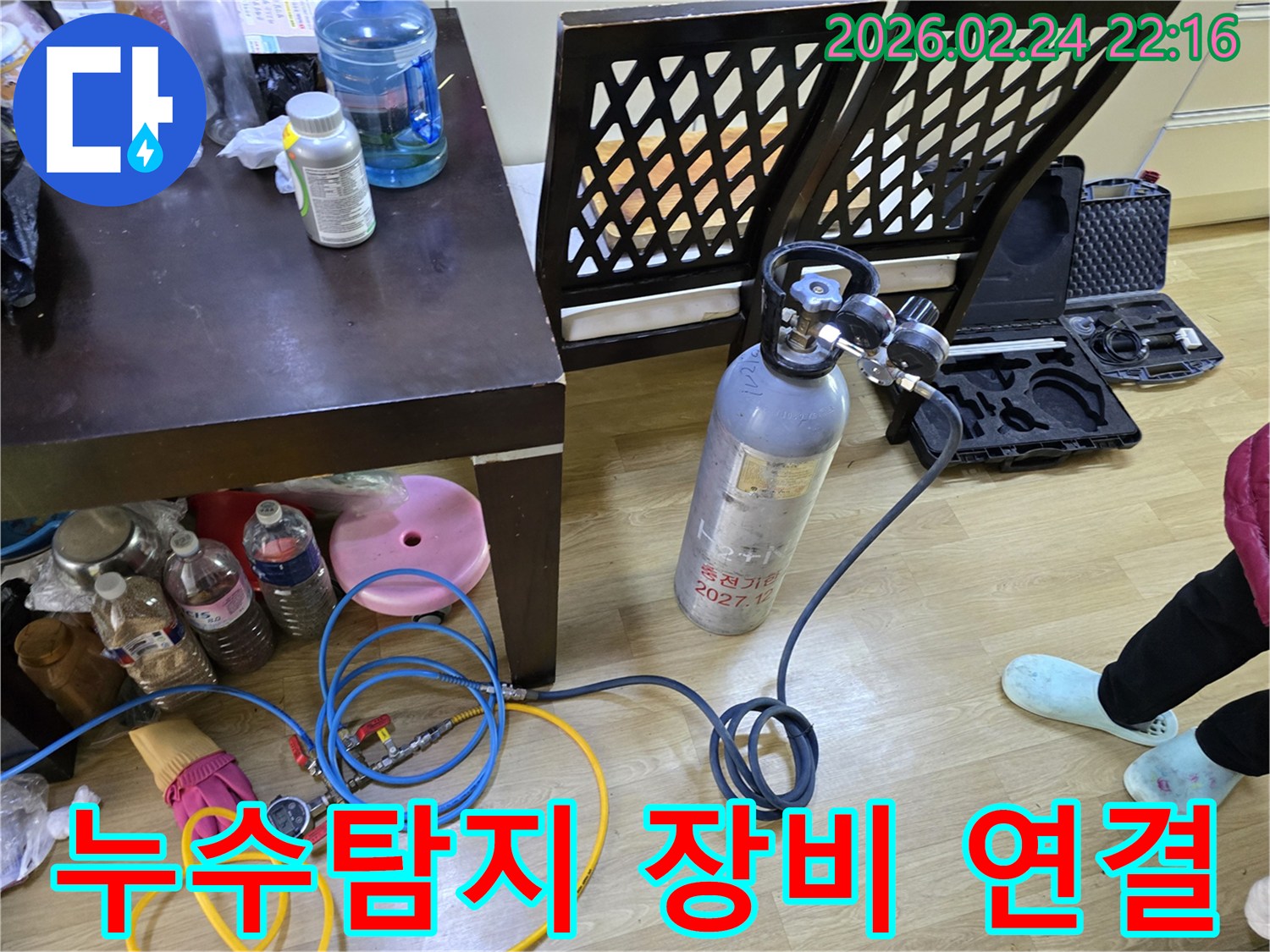 아파트 누수 원인을 파악하기 위해-가스통과 압력계를 연결하여-배관 압력 테스트를 준비하는 모습