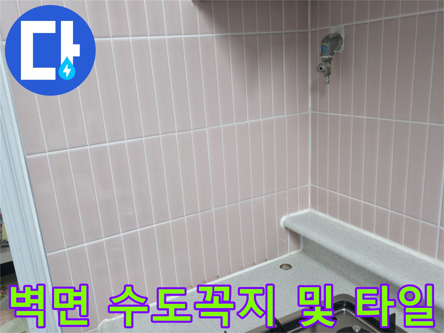 분홍색 세로 타일 벽면에 설치된 수도꼭지 사진