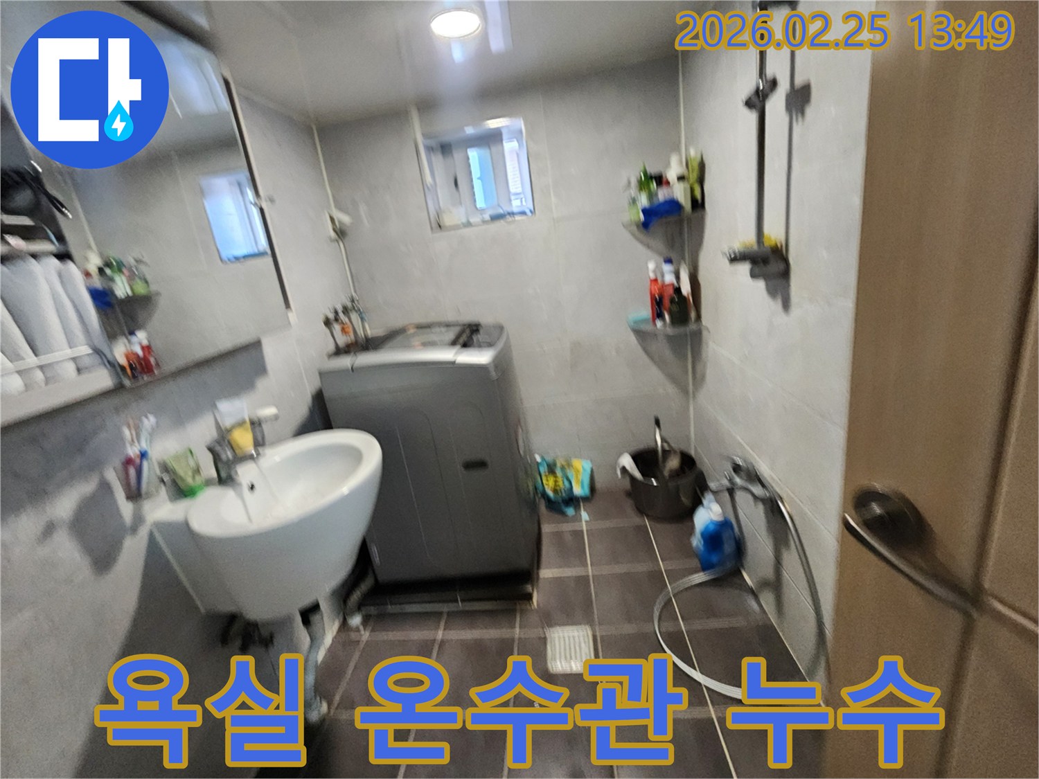 세탁기와-세면대가-있는-욕실에서-온수관-누수-여부를-정밀하게-점검하는-모습을-담은-사진