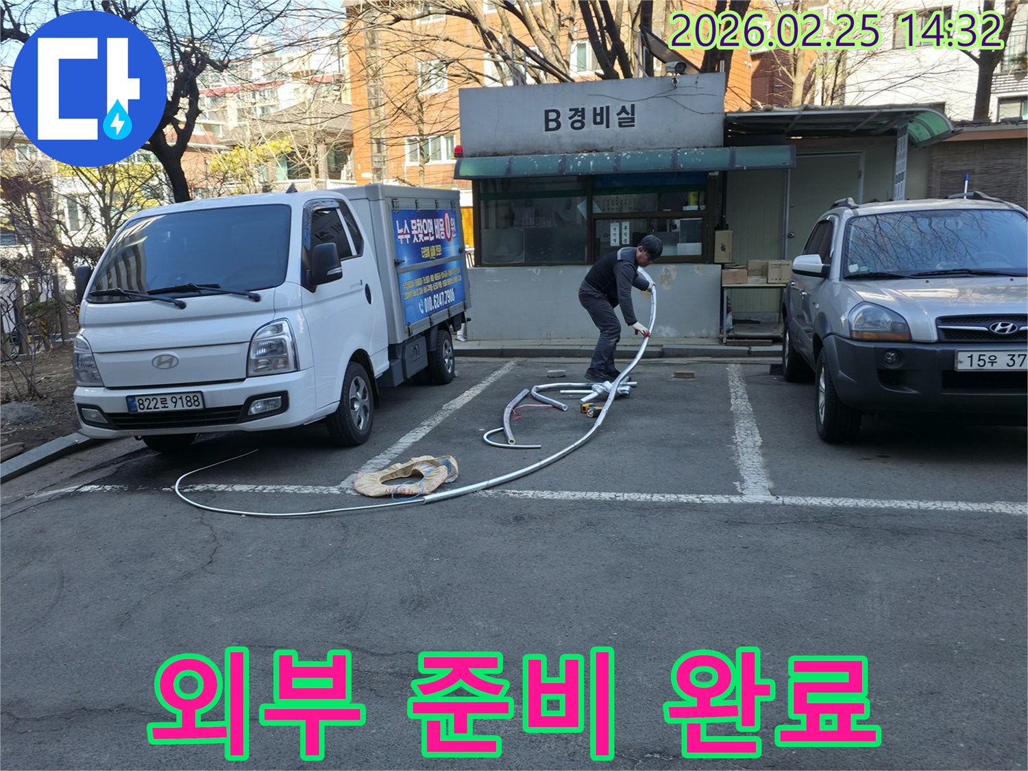 누수 전문 엔지니어가 건물 내부 진입에 앞서-모든 탐지 장비를 외부에서 완벽하게 준비하고 있습니다.