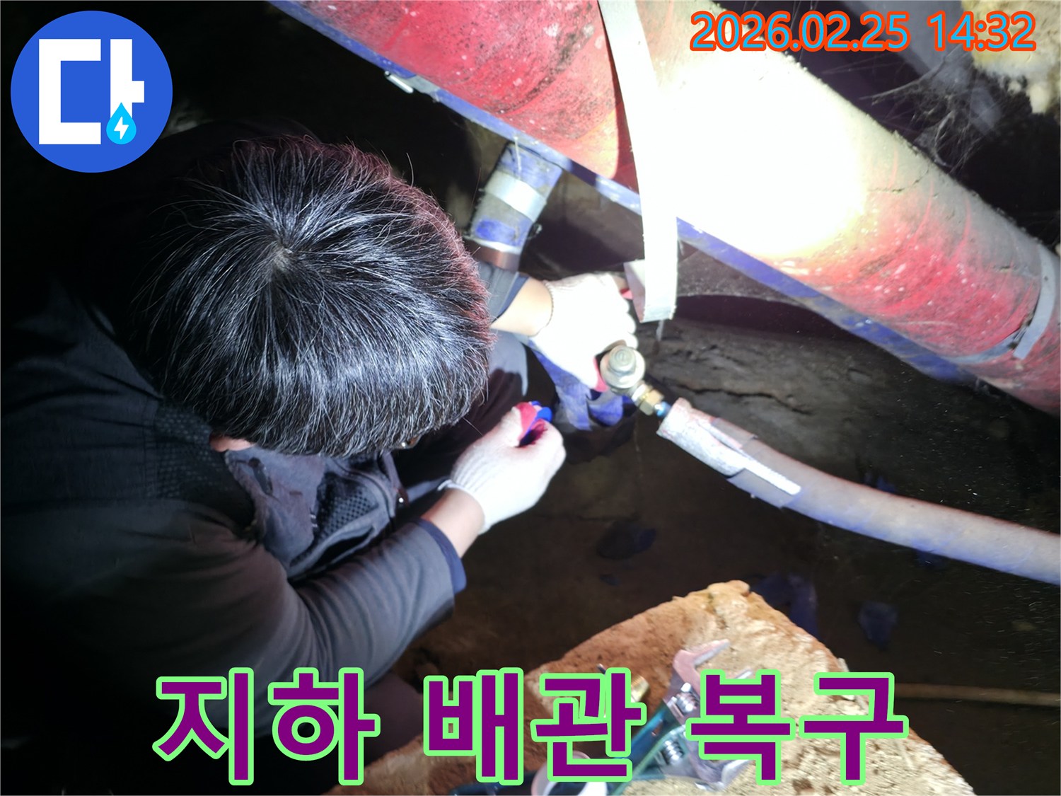 누수 전문 엔지니어가 어두운 지하 공간에서 손전등을 비추며 배관 연결 부위를 정밀하게 점검하고 복구하고 있습니다-지하누수해결-전문가복구