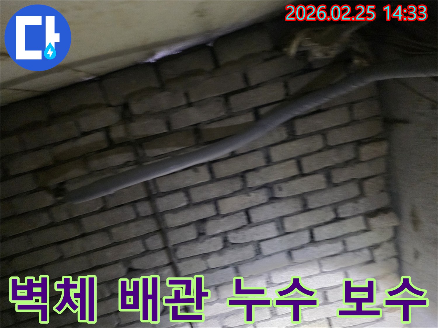 어두운 벽돌 벽면을 배경으로-단열된 배관과 함께-누수 여부를 확인하기 위해-정밀하게 검사되는 현장 모습입니다.