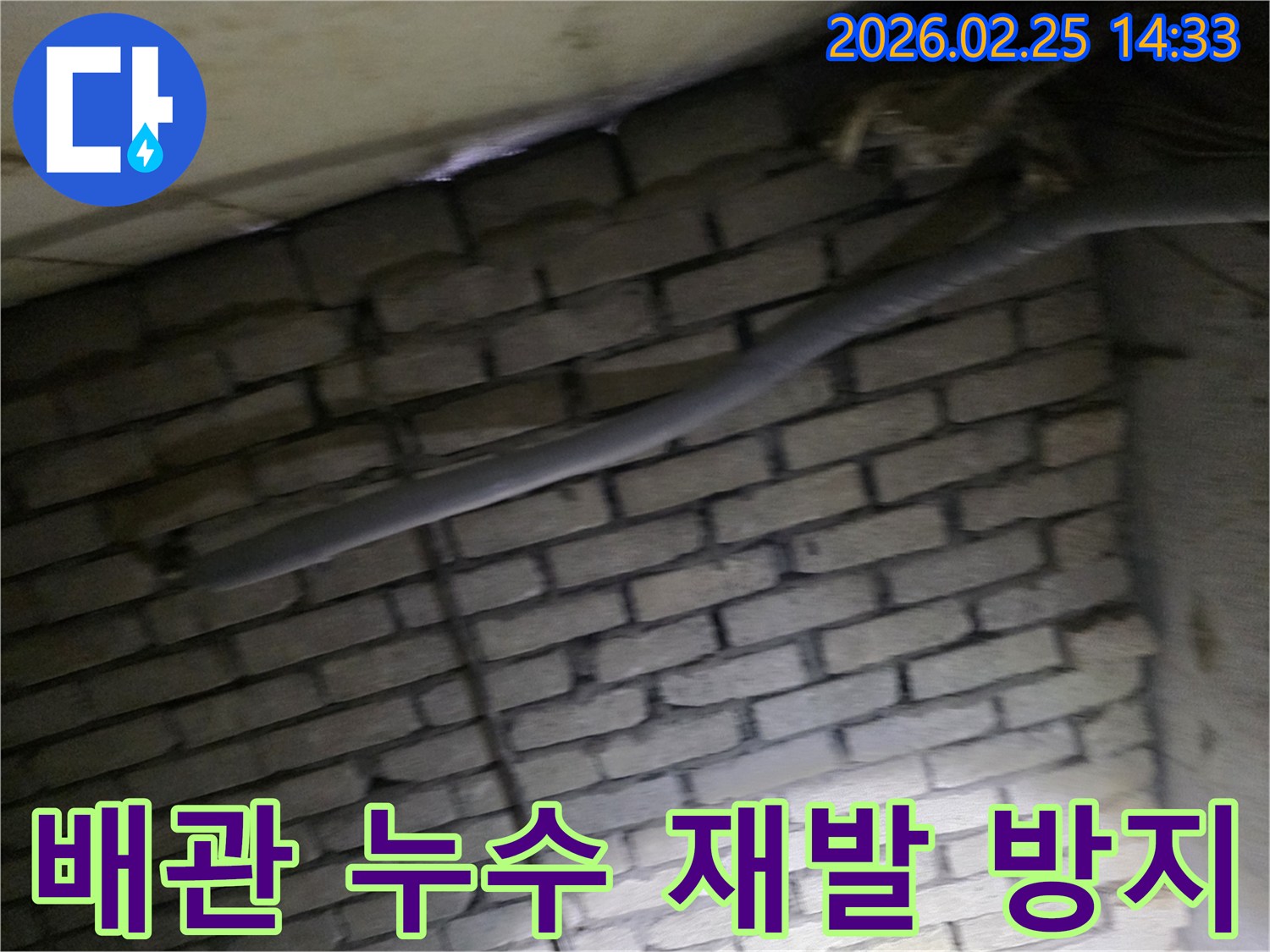 어두운 벽돌 벽면을 배경으로-단열된 배관과 함께-누수 지점을 탐지하고-재발 방지 대책을 세우는 현장 모습입니다.