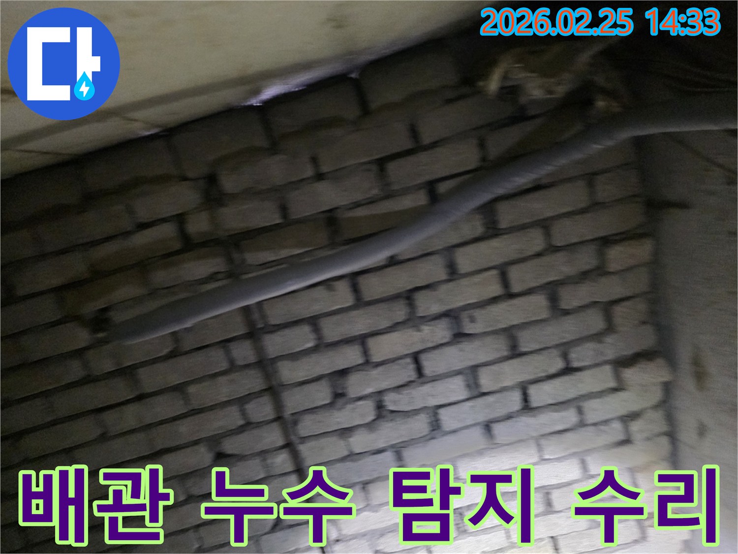 어두운 벽돌 벽면을 배경으로-단열된 배관과 함께-숨겨진 누수 지점을 탐지하고-수리하기 위해 검사되는 현장 모습입니다.