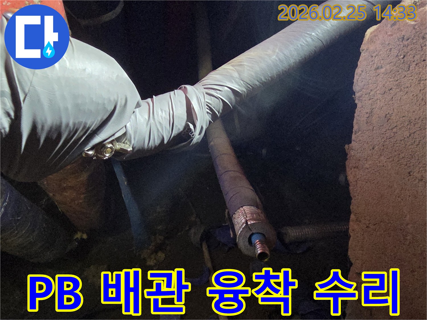 어두운 작업 공간에서-장갑을 낀 손이-PB 배관의-손상된 부분을-융착 기술로-견고하게 수리하는-모습을 담고 있습니다